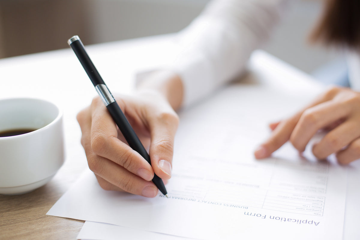 Woman completing an application for a resume for care giving job