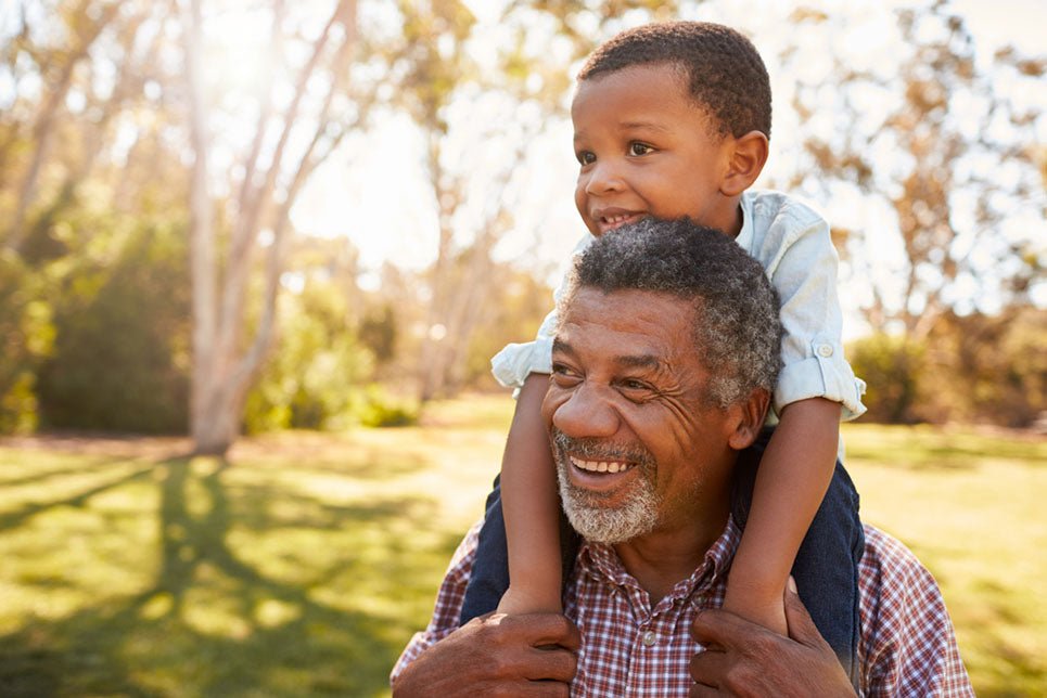 grandfather carrying grandson on back