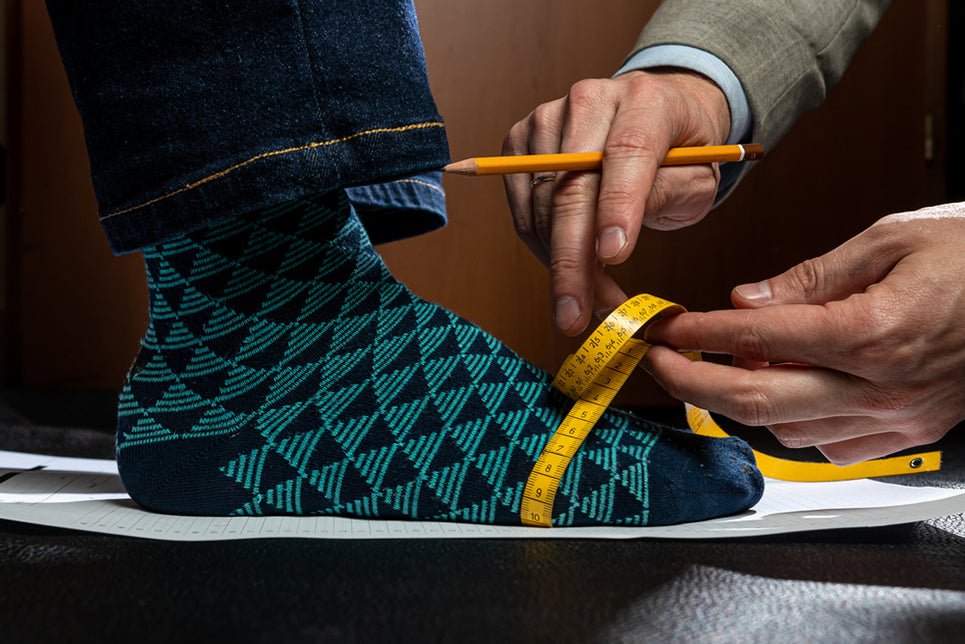 a person measuring the bridge of another persons foot