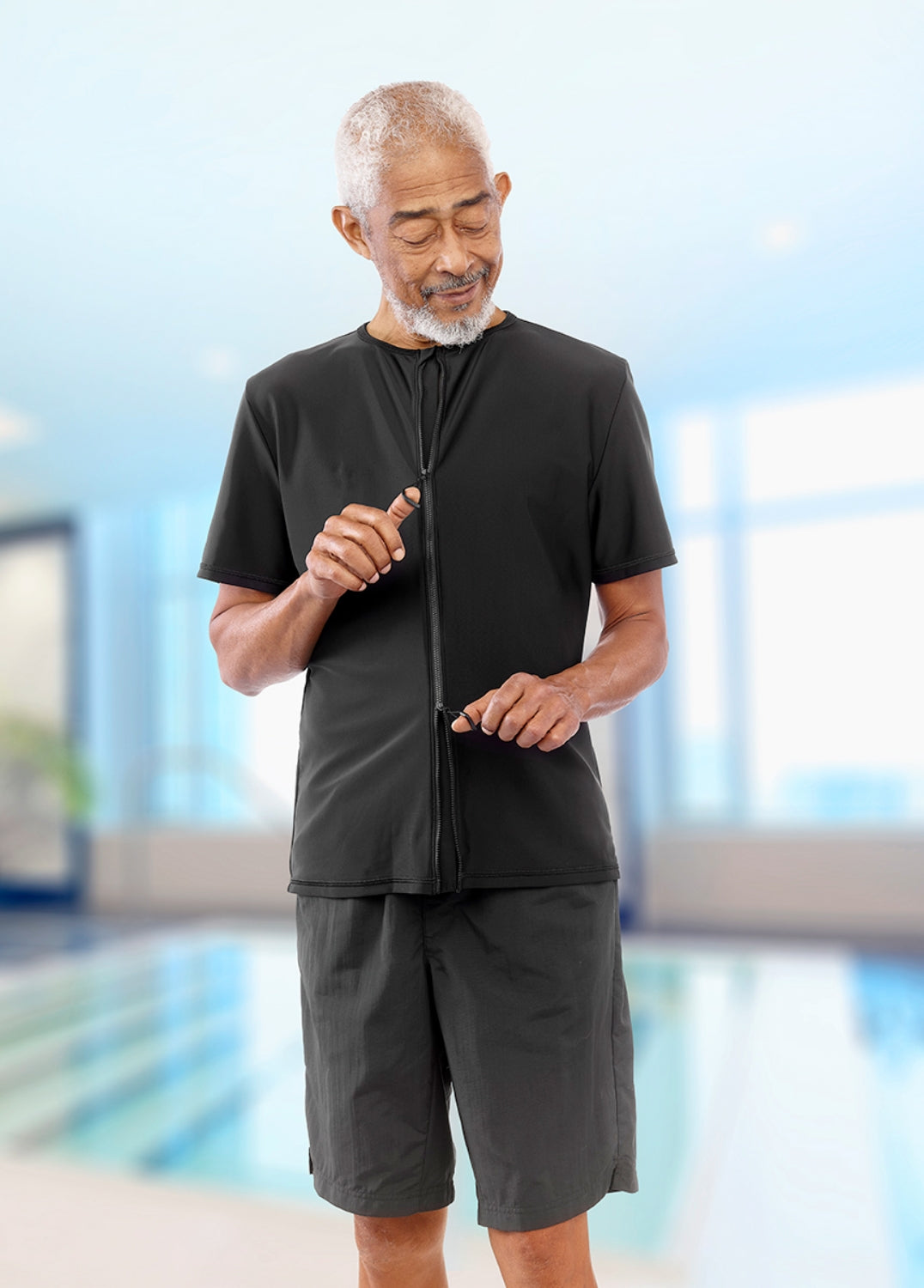 Man in black athletic outfit standing by a pool