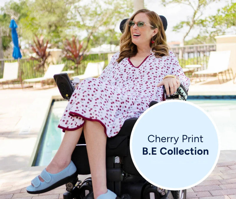 Woman in a cherry print B.E. Collection dress sitting by a pool.
